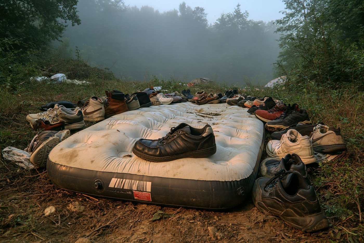 A single air mattress ringed by abandoned shoes